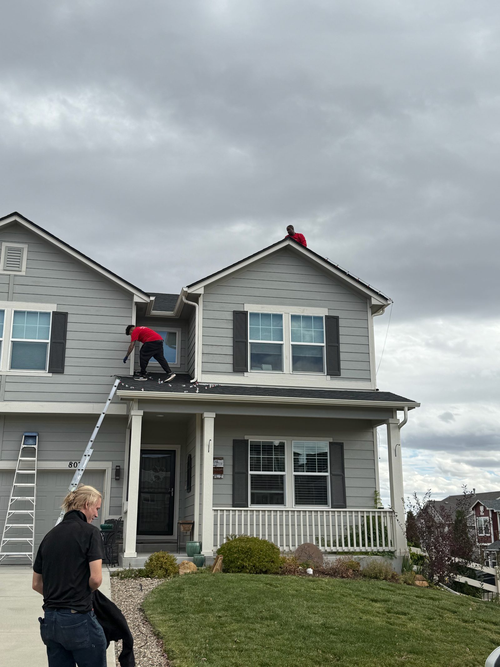Christmas Lights Colorado Springs crew installing warm white C9 Christmas lights on a two-story home roofline Christmas Lights Colorado Springs crew installing warm white C9 Christmas lights on a two-story home roofline