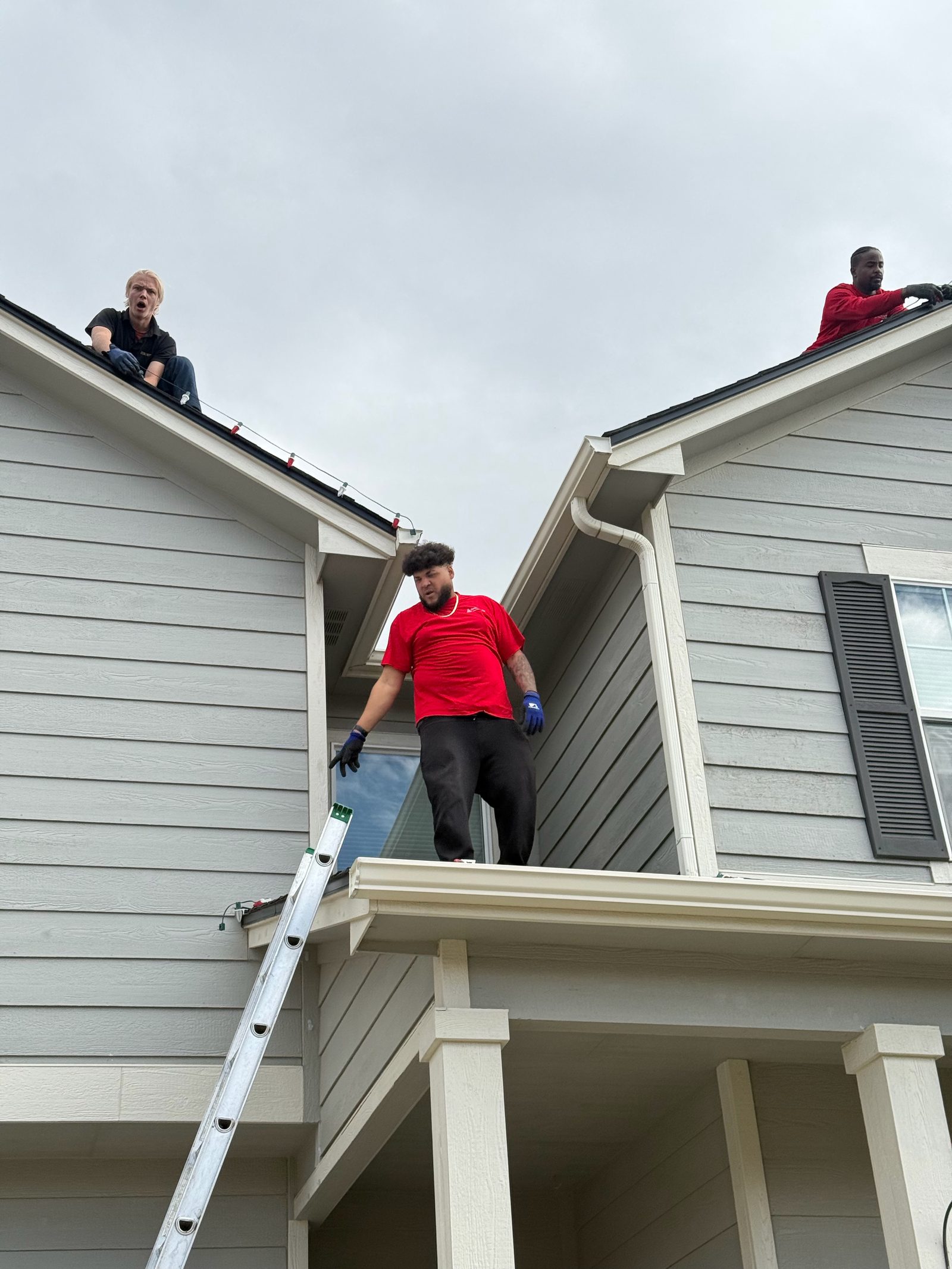 Christmas Lights Colorado Springs team installing multicolor Christmas lights along roof peaks Christmas Lights Colorado Springs team installing multicolor Christmas lights along roof peaks